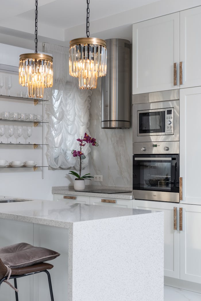 Bright modern kitchen interior with elegant lighting and stainless steel appliances.